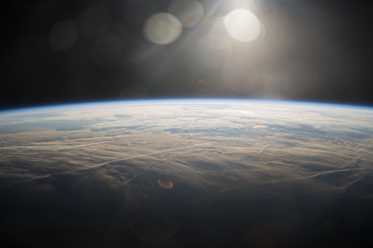 Sunrise breaking over the curved edge of Earth, seen from the International Space Station